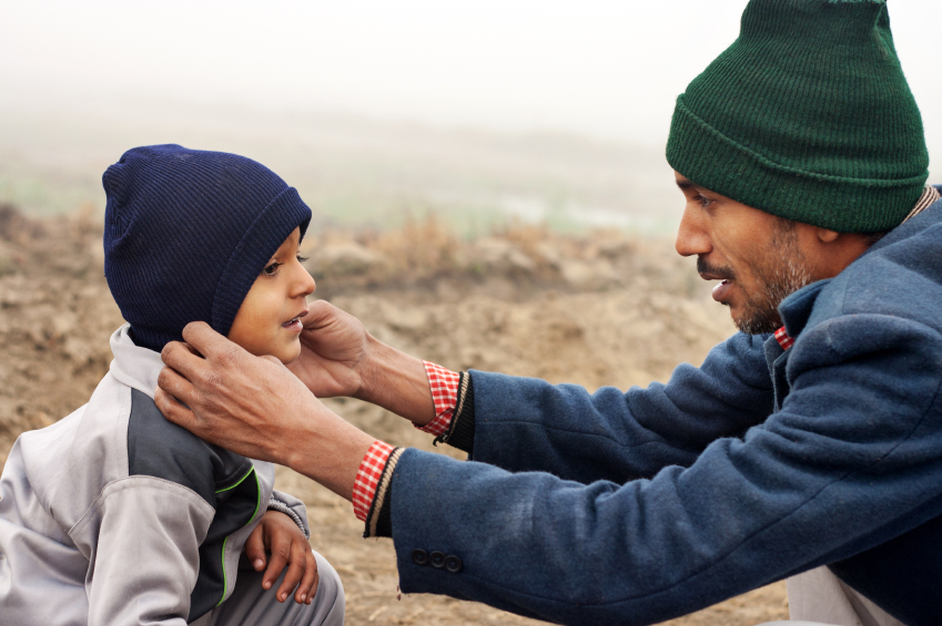 a dad adjusting his son's hat